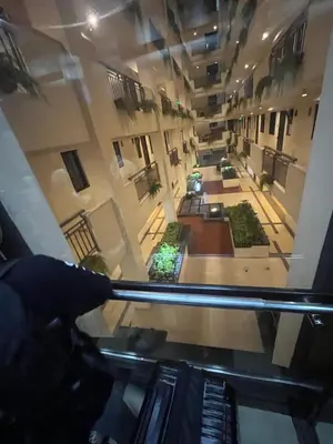 a person looking through a glass window at a building at Arista Place Condo 2 bedroom unit in Manila
