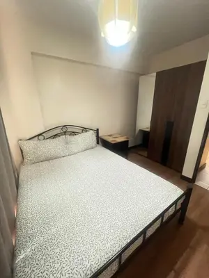 a bedroom with a bed in a room with a light at Arista Place Condo 2 bedroom unit in Manila