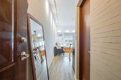 a hallway with a door and a room with a table at Yūgen 幽玄 Makati Home - Malls, Little Tokyo, Pool in Manila