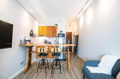 a kitchen with a table and stools in a room at Yūgen 幽玄 Makati Home - Malls, Little Tokyo, Pool in Manila