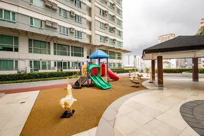 a playground in front of a building with a building at Yūgen 幽玄 Makati Home - Malls, Little Tokyo, Pool in Manila