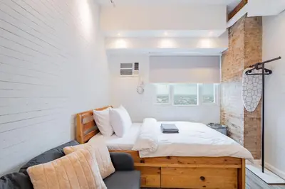 a bedroom with a bed and a couch at Yūgen 幽玄 Makati Home - Malls, Little Tokyo, Pool in Manila