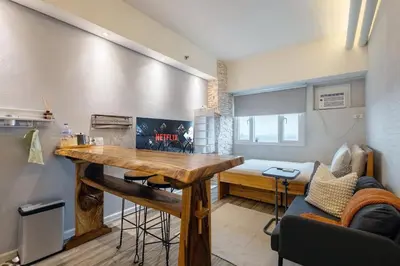 a kitchen with a wooden table in a room at Best Condo in Makati Near Airport and FREE Parking! in Manila