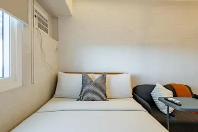 a small room with a bed and a chair at Best Condo in Makati Near Airport and FREE Parking! in Manila