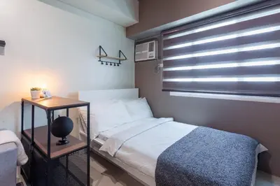 a small bedroom with a bed and a window at Makati Condo Near NAIA & Greenbelt - Free Parking! in Manila