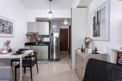 a kitchen with a refrigerator and a table and chairs at Makati Condo Near Airport & Greenbelt in Manila
