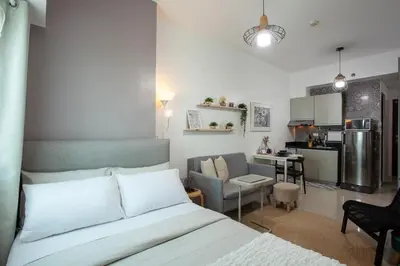 a living room with a bed and a kitchen at Makati Condo Near Airport & Greenbelt in Manila