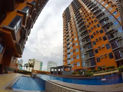 a swimming pool in front of a tall building at Portovita Towers in Manila