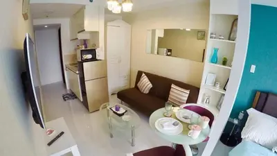 a small living room with a couch and a table at Portovita Towers in Manila