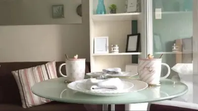 a table with two plates and two cups on it at Portovita Towers in Manila