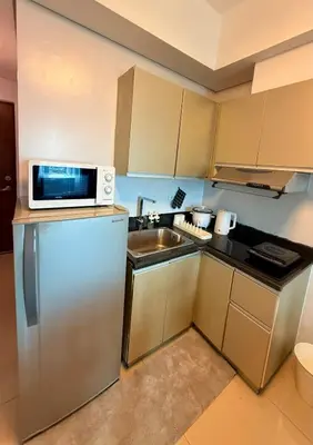 a small kitchen with a microwave and a sink at New Beacon Makati Condo Near Airport with Pool Access in Manila