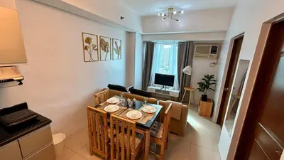 a kitchen and dining room with a table and chairs at New Beacon Makati Condo Near Airport with Pool Access in Manila