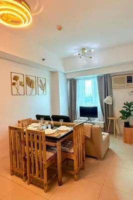a living room with a table and a couch at New Beacon Makati Condo Near Airport with Pool Access in Manila