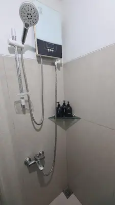 a shower in a bathroom with a sink and a shower head at New Beacon Makati Condo Near Airport with Pool Access in Manila