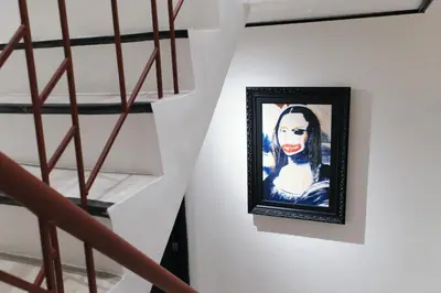 a painting of a woman on a wall next to a staircase at The Kin House - Poblacion Botique Hotel in Manila