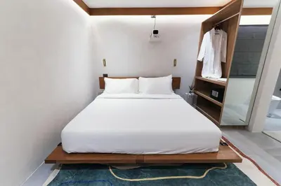 a bedroom with a large bed with a white sheets at The Kin House - Poblacion Botique Hotel in Manila