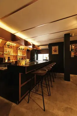 a bar with a row of stools in a restaurant at The Kin House - Poblacion Botique Hotel in Manila