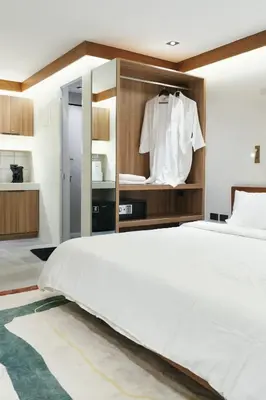a bedroom with a large white bed and a closet at The Kin House - Stay in Art Poblacion in Manila