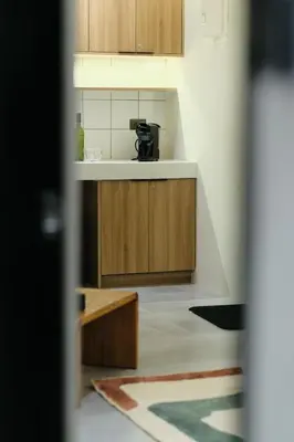 a kitchen with wooden cabinets and a coffee maker at The Kin House - Stay in Art Poblacion in Manila