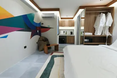 a bedroom with a white bed and a colorful wall at The Kin House - Stay in Art Poblacion in Manila