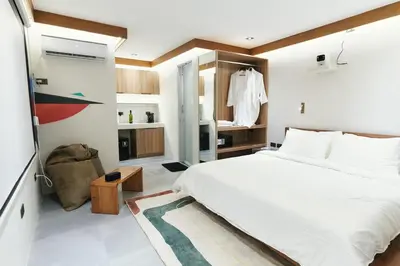 a bedroom with a large white bed and a bathroom at The Kin House - Stay in Art Poblacion in Manila