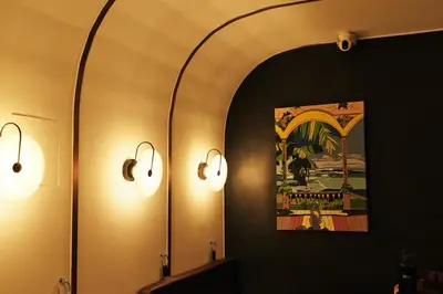 a bathroom with two lights and a mirror at The Kin House - Hotel in the Heart of Poblacion in Manila
