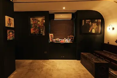 a living room with black walls and a mirror at The Kin House - Hotel in the Heart of Poblacion in Manila
