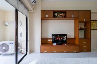a room with a entertainment center with a television in it at Relax & WFH in Vibrant & Cozy Greenbelt Condo with Pool in Manila