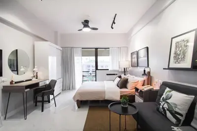 a white bedroom with a bed and a desk and a desk at NEW! Beautiful Studio in Greenbelt Makati in Manila