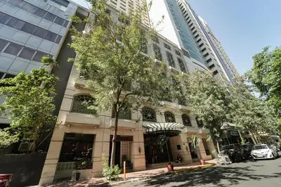 a tall building with a tree in front of it at NEW! Modern Condo in Greenbelt Makati with Pool & Gym in Manila