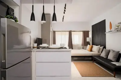 a kitchen and living room with a couch and a bed at NEW! Modern Condo in Greenbelt Makati with Pool & Gym in Manila