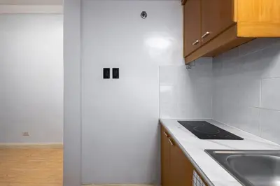 a kitchen with a sink and a stove top oven at Charming Studio in Greenbelt Makati - Near Malls! in Manila