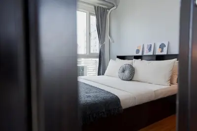 a bedroom with a bed with white pillows and a window at Free Parking! Beautiful 2BR Home in Central Makati in Manila