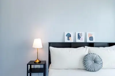 a bedroom with a white bed with a blue wall at Free Parking! Beautiful 2BR Home in Central Makati in Manila