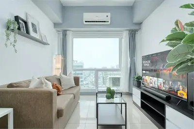 a living room with a couch and a flat screen tv at Free Parking! Beautiful 2BR Home in Central Makati in Manila