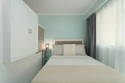 a small white bedroom with a bed and a window at Studio in Greenbelt Makati with Fiber WiFi & Free Pool Access in Manila