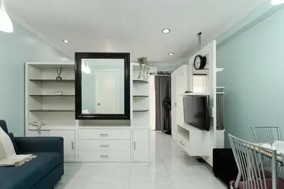 a living room with a blue couch and a mirror at Studio in Greenbelt Makati with Fiber WiFi & Free Pool Access in Manila
