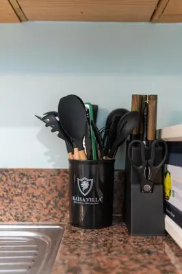 a black container of kitchen utensils on a counter at Studio in Greenbelt Makati with Fiber WiFi & Free Pool Access in Manila
