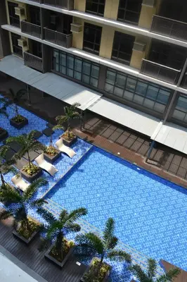 an overhead view of a large swimming pool with palm trees at Gentry Manor Pet Friendly Near MOA&NAIA Okada Complex 8T in Manila