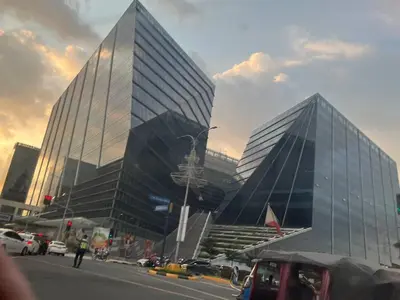 a large glass building with cars parked in front of it at Gentry Manor Pet Friendly Near MOA&NAIA Okada Complex 8T in Manila