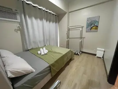 a bedroom with a bed with two candles on it at Gentry Manor Pet Friendly Near MOA&NAIA Okada Complex 8T in Manila