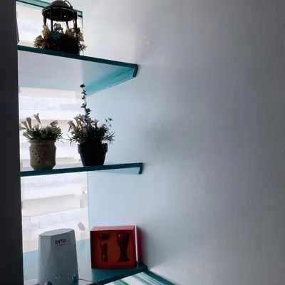a shelf with potted plants on a wall at Baywatch tower 1604 in Manila