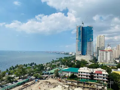 a view of a city and the ocean with buildings at Baywatch tower 1604 in Manila