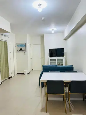 a room with a white table and blue chairs at Urban Resort District in Manila