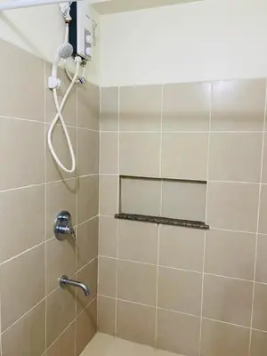 a bathroom with a shower with a shower head at Urban Resort District in Manila