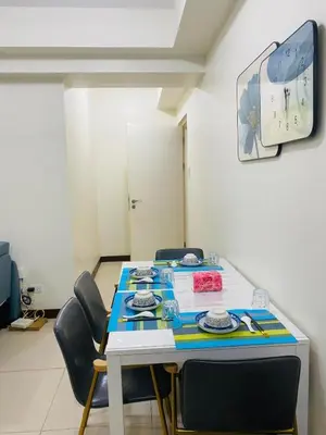 a room with a table with chairs and a clock at Urban Resort District in Manila