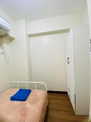 a bedroom with a bed with a blue towel on it at Urban Resort District in Manila