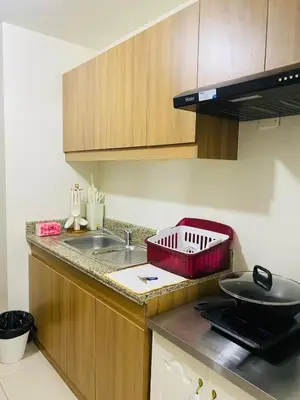a kitchen counter with a sink and a red basket on it at Urban Resort District in Manila
