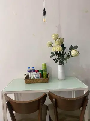 a table with a vase of flowers and two chairs at Ohana Buenbyahe Studio Rooms with balcony in Mandaluyong, Edsa Shaw Mrt and Megamall in Manila