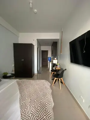 a living room with a bed and a flat screen tv at Nature Inspired Affordable Rooms in F RESIDENCE near Edsa Shaw Pasig Megamall Shangrila and MRT in Manila